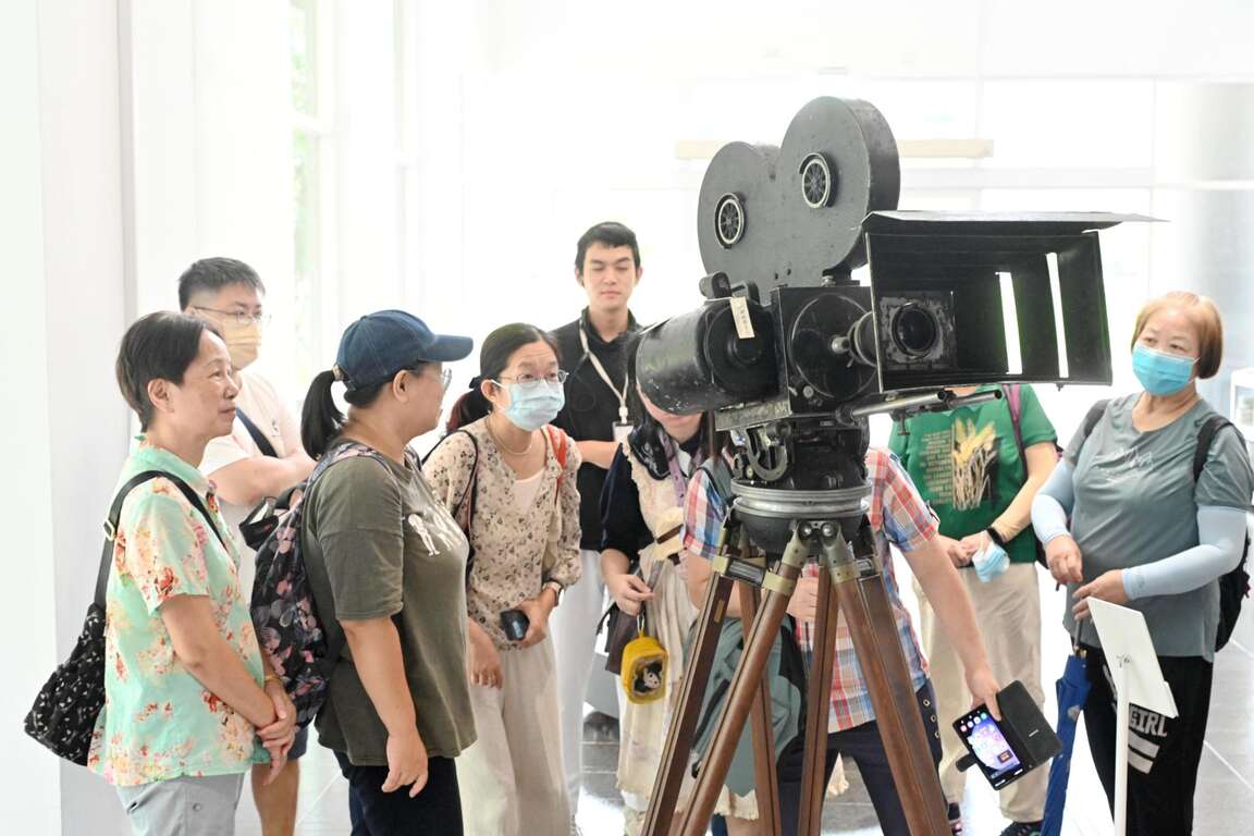 粉絲仔細觀看新莊國家級影視殿堂-國家電影及視聽文化中心中收藏的老式攝影機。