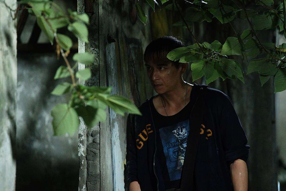 天台上的魔術師-腳色倚靠牆面